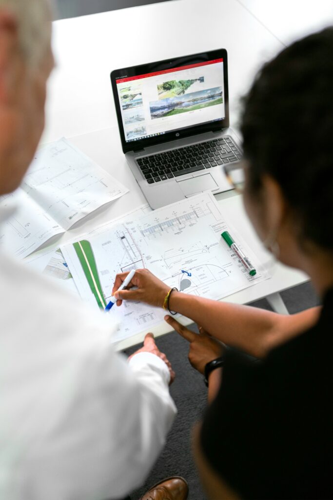 Equipe de engenharia revisando plantas de projeto na etapa de viabilidade de um empreendimento